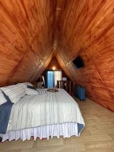 LaresCabaña 787的卧室设有一张木制天花板上的大床