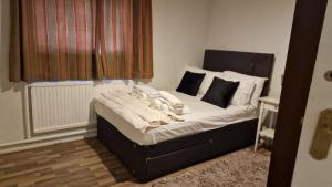伦敦House的一间卧室配有带白色床单和枕头的床。