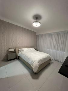圣多明各Moderno apartamento en Naco的卧室配有白色的床和灯