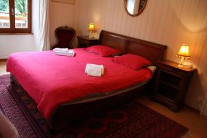 Versegeres La Petite Auberge的一间卧室配有红色的床和2条毛巾