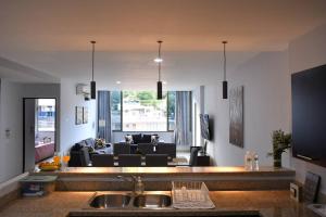 圣萨尔瓦多Los Cielos302: Spacious Condo with scenic views.的厨房以及带沙发的起居室。