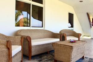 乌图罗阿Tekauhivai Lodge的客房设有藤椅、桌子和窗户。