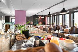 索尔纳Aiden by Best Western Stockholm Solna的用餐室配有桌椅和食物