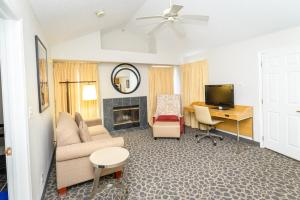 费城Philadelphia Suites at Airport - An Extended Stay Hotel的带沙发、书桌和电视的客厅