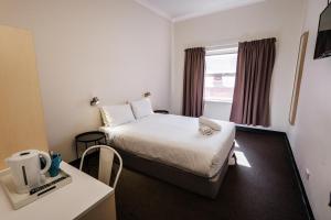 阿德莱德YHA Adelaide Central的小型酒店客房配有一张床和一张桌子