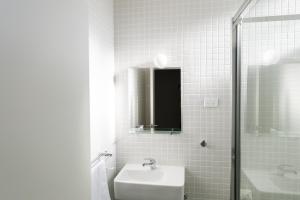 Port BroughtonPort Broughton Hotel and Sunnyside Motel的白色的浴室设有水槽和淋浴。