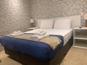 圣保罗GoodStay São Paulo Ibirapuera的一间卧室配有一张大床和毛巾