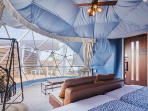 IchinomiyaSeage Torami Coastside的一间卧室设有蓝色的墙壁和一张天花板床。