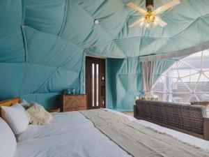 IchinomiyaSeage Torami Coastside的蓝色客房内设有一张大床