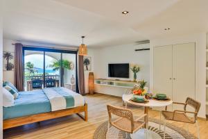 东方湾Orient bay - Apartment Oceanview - Alamanda beach residence的一间卧室配有一张床和一张桌子及椅子