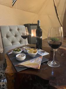 PueloAlma Andina的一张桌子,上面放有两杯酒和一瓶葡萄酒