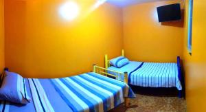 阿里卡Hostal Arica 2的黄色墙壁客房的两张床