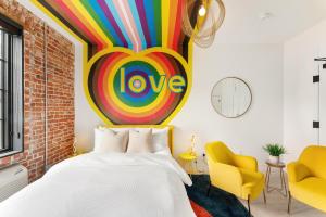 丹佛The Acoma House的卧室配有一张床,墙上挂着色彩缤纷的爱情标志