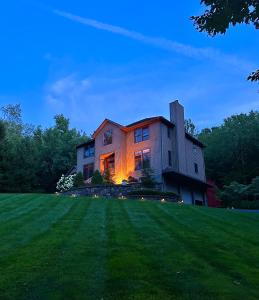 门罗Villa Verde B&B, bsm, Greenwood Lake, NY的山上的房屋,灯火照亮