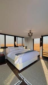 ShāhiqOman desert private camp的卧室设有一张大白色的床和大窗户