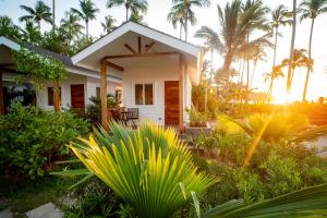 爱妮岛Nacpan Beach Villas的一座棕榈树成荫的白色小房子