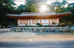 顺天市Doyosae Hanok Pension的亚西亚风格的建筑,背面是阳光