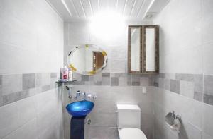 顺天市Doyosae Hanok Pension的浴室设有蓝色的卫生间和镜子