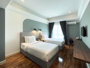 马六甲Hotel Seri Costa的酒店客房设有两张床和电视。