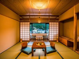 下吕市Yukai Resort Premium Gero Saichoraku Honkan的日式客房配有桌椅