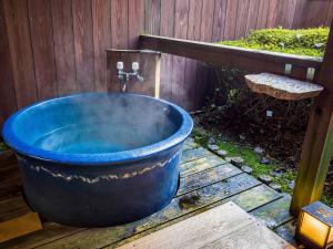 下吕市Yukai Resort Premium Gero Saichoraku Honkan的大型蓝色浴缸,带水水龙头