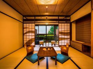 下吕市Yukai Resort Premium Gero Saichoraku Honkan的客房设有桌椅和窗户。