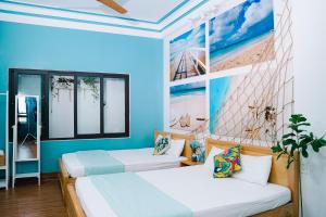 归仁Blossom Sea Homestay Quy Nhơn的蓝色墙壁客房的两张床