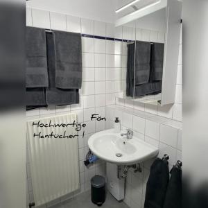 奥尔登堡Modernes Apartment in Oldenburg的浴室配有盥洗盆、镜子和毛巾