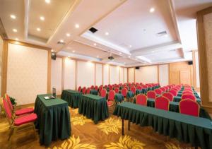 上海维也纳国际酒店(上海交大沪闵路店)的一间会议室,配有绿色的桌子和红色的椅子