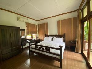 清迈ANANTAYA CHIANGMAI BOUTIQUE HOTEL的一间卧室配有一张床和一架钢琴
