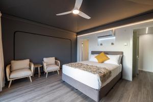 Townsville Eco Resort的一间卧室配有一张床和两把椅子