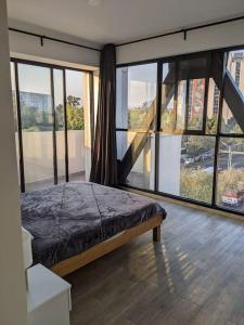 墨西哥城Right @Reforma - Beautiful condo with 2 balconies的一间卧室设有床铺和大型玻璃窗