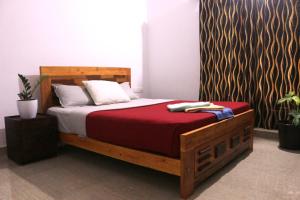 卡尔佩特塔Coffee Roots的一间卧室配有一张带红色毯子的木床