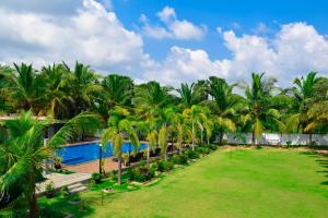 亭可马里绿色花园酒店的一个带游泳池和棕榈树的度假村