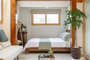 首尔Memory Stay Seoul Jongro Hanok的一间卧室配有一张床和盆栽植物