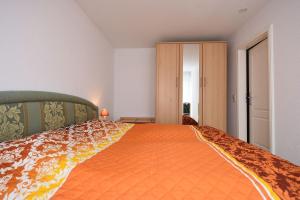 巴贝Ferienwohnung-6-15的一间卧室配有一张带橙色床罩的大床