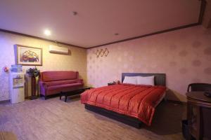 釜山Shine Motel的一间卧室配有红色的床和红色椅子