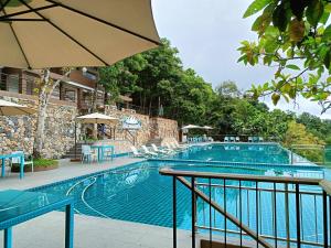 宿务Mist Mountain Resort powered by Cocotel的一个带椅子和遮阳伞的大型游泳池