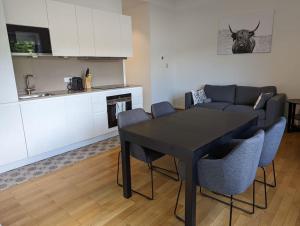 卢森堡Refurbished 1BR Apartment in Limpertsberg的客厅配有黑色的桌子和椅子