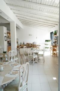 尼科洛西米开朗基罗别墅酒店的用餐室配有白色的桌子和白色的椅子