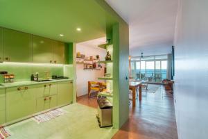 丰沙尔Oceanfront 2-bedroom Apartment in Praia Formosa的一间设有绿色橱柜的厨房和一间用餐室