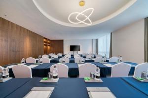 杭州杭州拱墅大运河逸扉酒店 的一间会议室,配有蓝色的桌子和白色的椅子