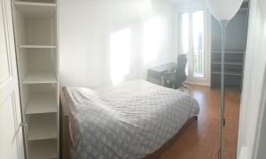 吕埃尔-马尔迈松Appartement cosy 6 personnes proche gare的一间卧室配有一张床、一张书桌和一个窗户。