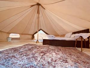 BadīyahDesert Stars Camp的一个大帐篷,里面设有一张床