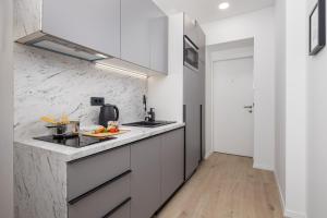 里耶卡Area1 Center Luxury Apartment with sauna的厨房配有白色橱柜和大理石墙
