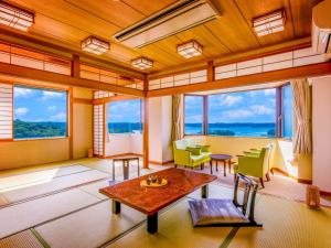 志摩市Yukai Resort Premium Shima Saichoraku的客厅设有窗户和桌椅