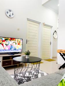 班图尔Homestay Kamar Tamu Sedayu的客厅配有桌子和平面电视。