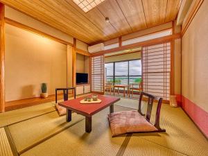 志摩市Yukai Resort Premium Shima Saichoraku的配有桌椅和电视的客房
