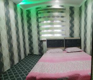 ChimganДом у подножия гор的一间卧室配有一张带粉色床单的床和一扇窗户。