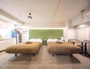 大阪住一心斋桥店的绿墙客房的两张床